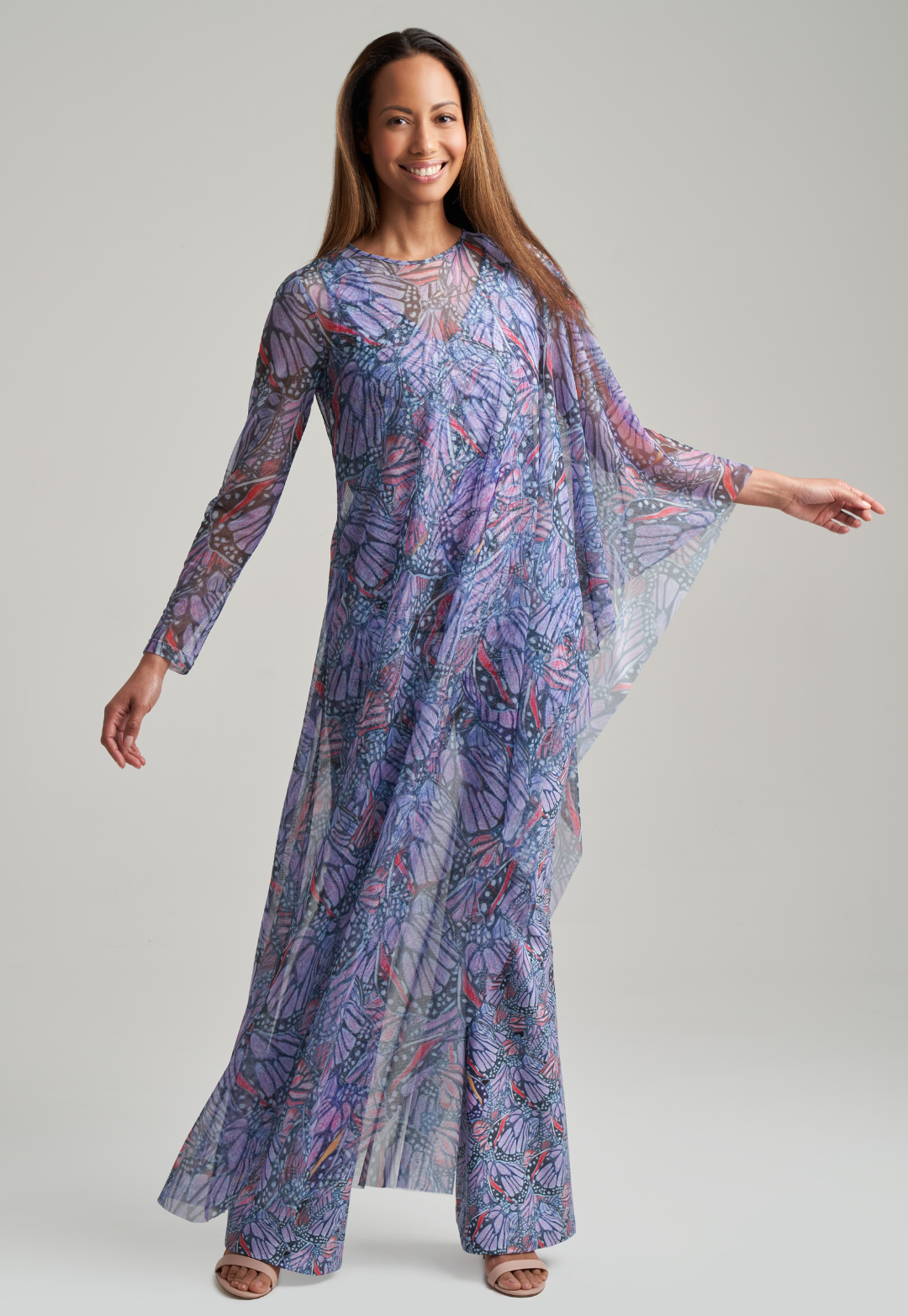 Woman wearing butterfly printed stretch knit purple pants with butterfly printed purple stretch knit tank top under sheer mesh butterfly printed poncho by Ala von Auersperg for spring summer 2021