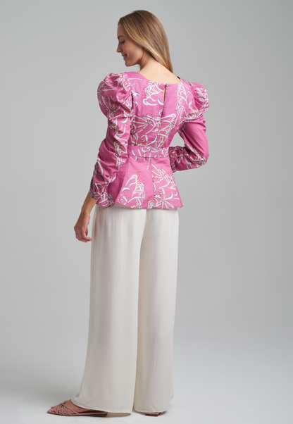 Woman wearing cotton puffed sleeve square neck blouse with belt in watermelon spider lily print by Ala von Auersperg for spring summer 2021