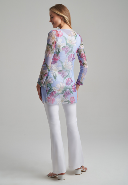 Woman wearing tulip printed mesh tunic with stretch knit white pants and tank top in white by Ala von Auersperg for spring summer 2021