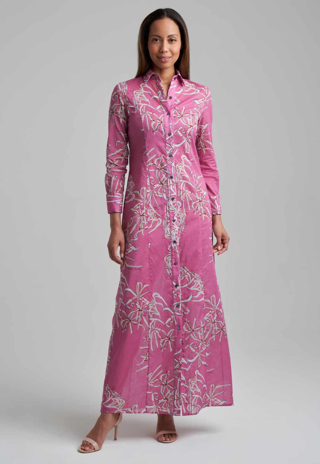 Woman wearing long cotton shirt dress in pink spider lily print by Ala von Auersperg for spring summer 2021