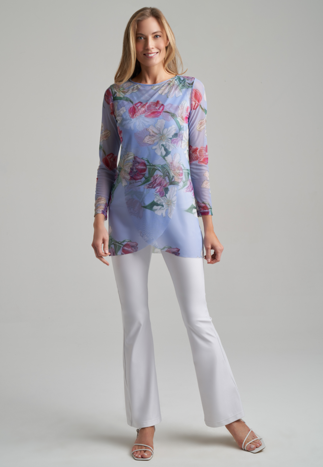 Woman wearing tulip printed mesh tunic with stretch knit white pants and tank top in white by Ala von Auersperg for spring summer 2021