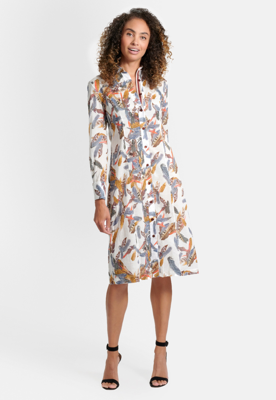 Woman wearing cotton white feather printed shirt knee length dress with French cuffs by Ala von Auersperg for fall 2020