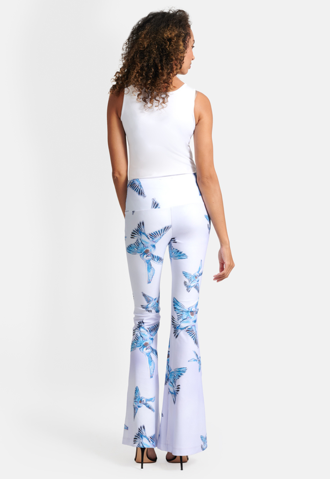 Woman wearing stretch knit lavender love birds printed pants with white stretch knit tank top by Ala von Auersperg