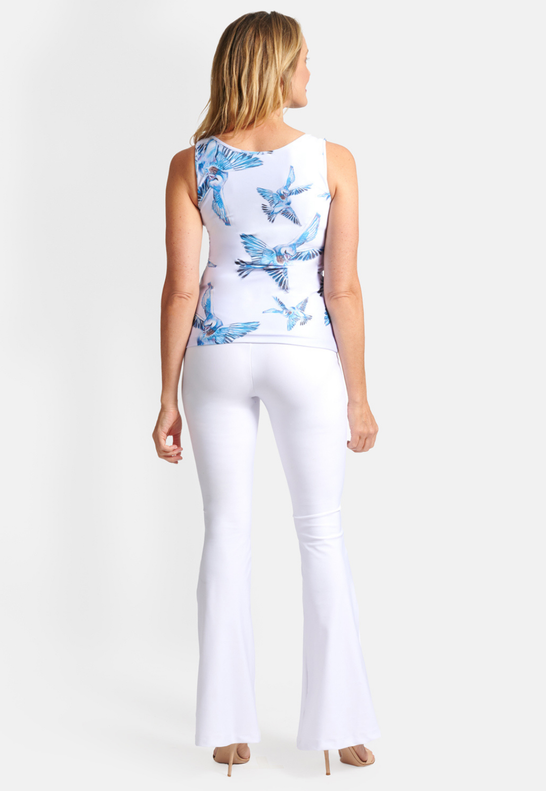 woman wearing love birds lavender printed stretch knit v neck tank top and stretch knit white pants by Ala von Auersperg