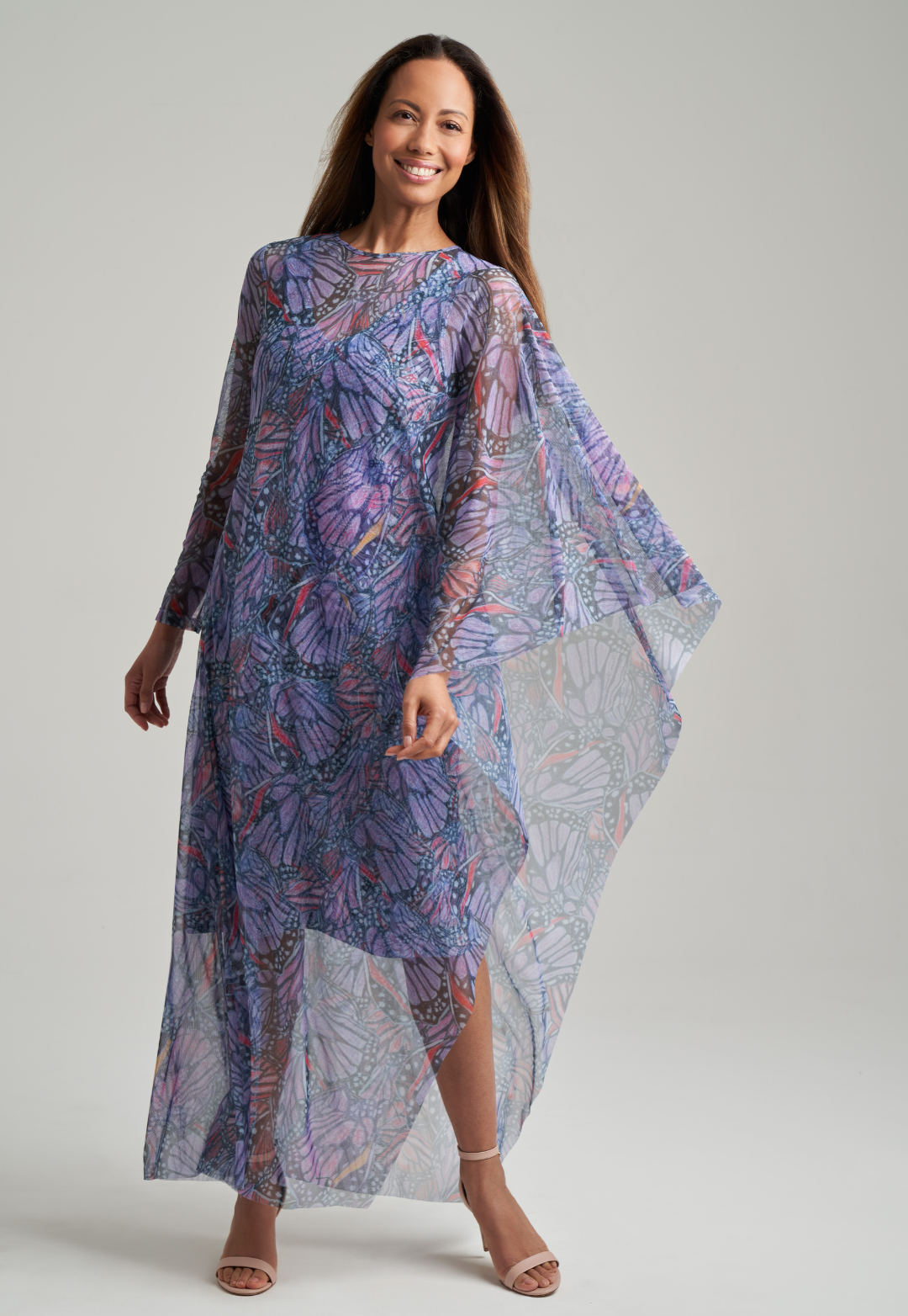 Woman wearing stretch knit butterfly printed short dress under mesh one armed butterfly printed kaftan poncho by Ala von Auersperg for spring summer 2021